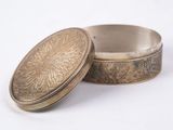an antique silver box with a lid sitting on a white surface