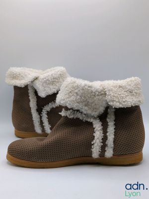 a close up of a pair of brown shoes with white fur on them