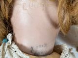 a close up of a doll ' s head with a tattoo on it
