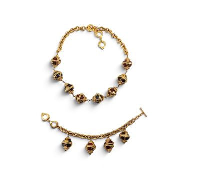 un gros plan d'un collier et d'un bracelet sur fond blanc
