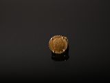a close up of a gold coin sitting on top of a black surface