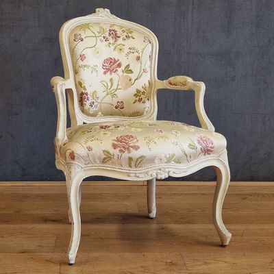 a white chair with a floral upholstered on it