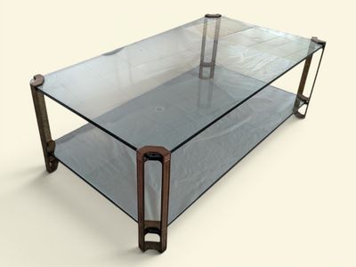 une table basse en verre avec des pieds en métal et un plateau en verre