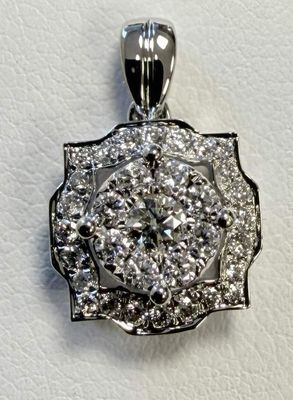 a close up of a diamond pendant on a white surface