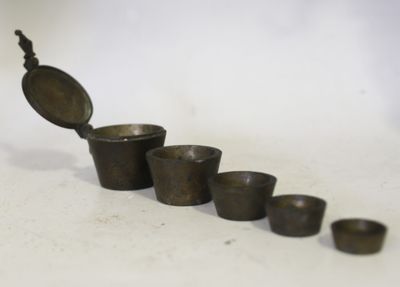 cinq tasses et une cuillère posées les unes à côté des autres sur une table