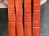 trois livres orange posés sur un canapé, à côté d'un fauteuil