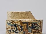 a close up of a piece of pottery with graffiti on it