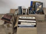 de nombreux livres rangés dans des cartons posés les uns à côté des autres sur le sol
