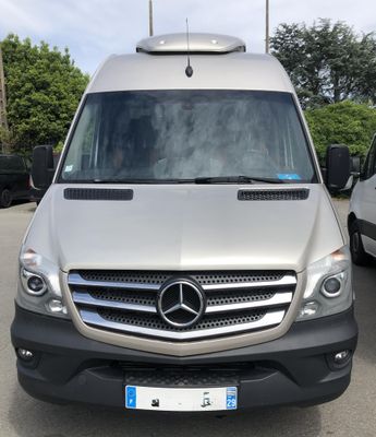 Le monospace Mercedes est garé sur un parking, à côté d'autres voitures.