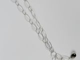 collier à chaîne en argent avec des perles noires sur fond blanc