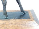 a statue of a man riding a horse on a wooden base