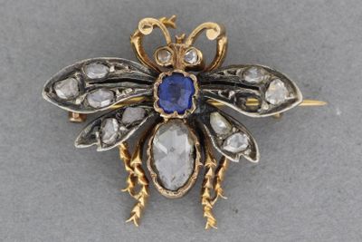 une image représentant une broche en forme d'abeille ornée d'une pierre bleue en son centre