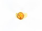 une bague en or jaune avec une face ovale et une petite face