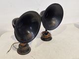 une paire de lampes noires posées sur une table blanche, avec un fond blanc