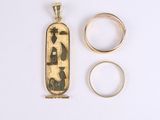 two gold rings and a gold pendant with a picture of a man and a woman