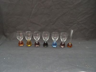 six wine glasses are lined up in a row on a gray background