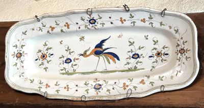 un grand plat sur lequel est posé un oiseau, posé sur une table