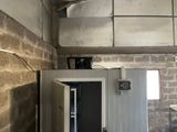 a metal cabinet in a room with a brick wall behind it