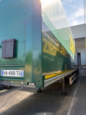 un gros camion vert garé sur un parking