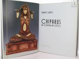 an open book with a statue of a woman sitting on top of a table