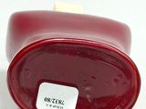 a close up of a red vase with a label on it