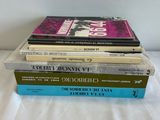 three books stacked on top of each other on a bed