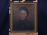 Une peinture à l'huile représentant une femme en robe noire est posée sur un chevalet.