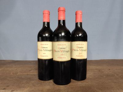 three bottles of red wine sitting on top of a wooden table