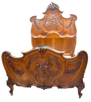 a wooden bed with a carved headboard and foot board
