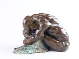 une statue représentant un singe assis sur un rocher