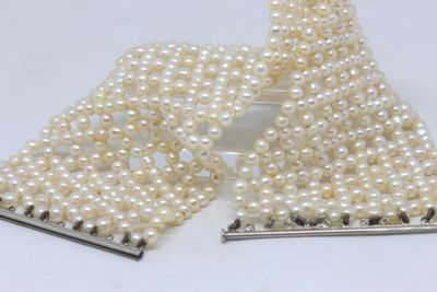 two pieces of white pearls and a pair of silver hair clips