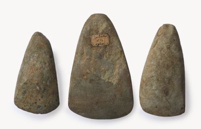 trois morceaux de pierre sont disposés en rangée sur une surface blanche