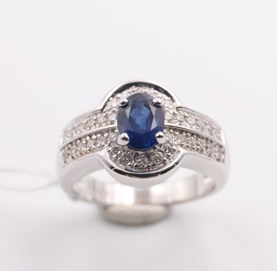 a close up of a sapphire and diamond ring on a white background