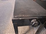 a black table with a black top on a carpeted floor