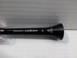 a black toothbrush that is laying on a white surface