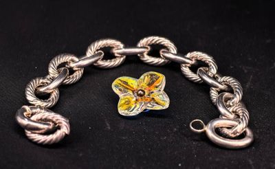 bracelet à chaîne en argent orné d'un pendentif en forme de fleur jaune sur fond noir