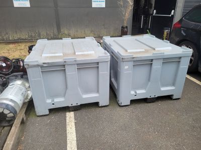 two boxes sitting next to each other in a parking lot