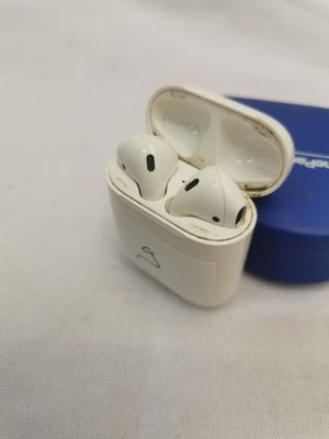 deux AirPods posés dans un étui bleu sur une surface blanche