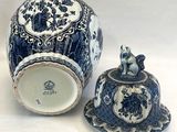 un vase bleu et blanc et une assiette posés sur une table