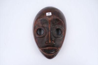gros plan d'un masque en bois sur une surface blanche