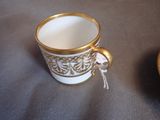 a cup and saucer sitting on a table next to each other
