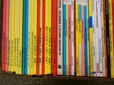 une boîte remplie de livres pour enfants posée par terre
