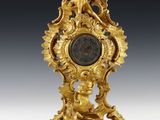 l'image d'une horloge en or posée sur une table