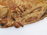 a close up of a gold plate with a bird on it