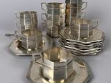 a silver plate with cups and saucers on it