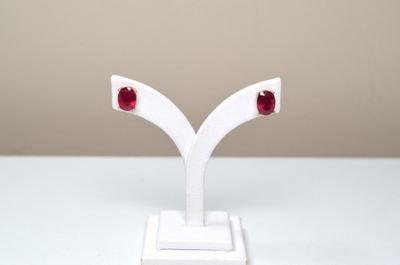 pair of red stone earrings on white stand on white surface