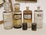 de nombreux vieux flacons de médicaments posés sur une table