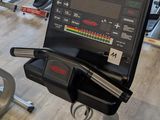 many tread machines in the gym with a laptop on one of them