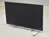a flat screen tv sitting on the floor with remotes