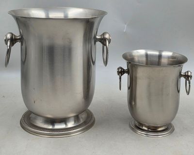 deux vases en argent posés l'un à côté de l'autre sur une table